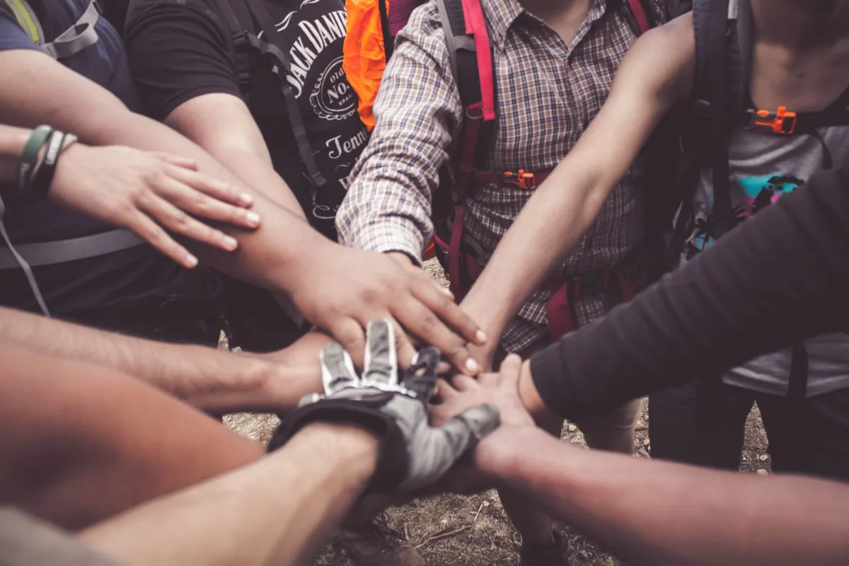 A group of people placing their hands together in a pile